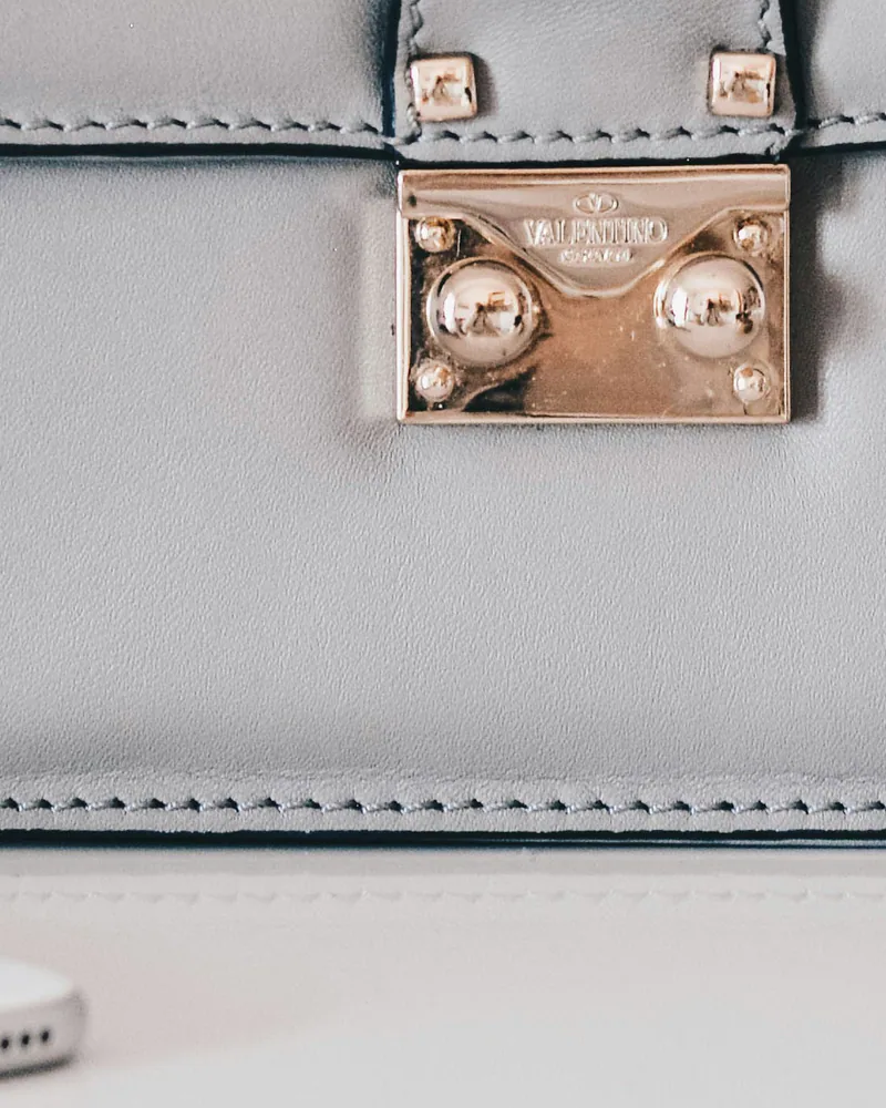 Close-up of light-gold studs on a grey Valentino Rockstud